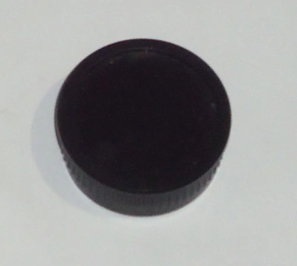 Schwarzer Knopf mit geriffeltem Rand, möglicherweise für eine Steuerungseinheit oder Fernbedienung von Daikin-Geräten, auf weißem Hintergrund abgebildet.